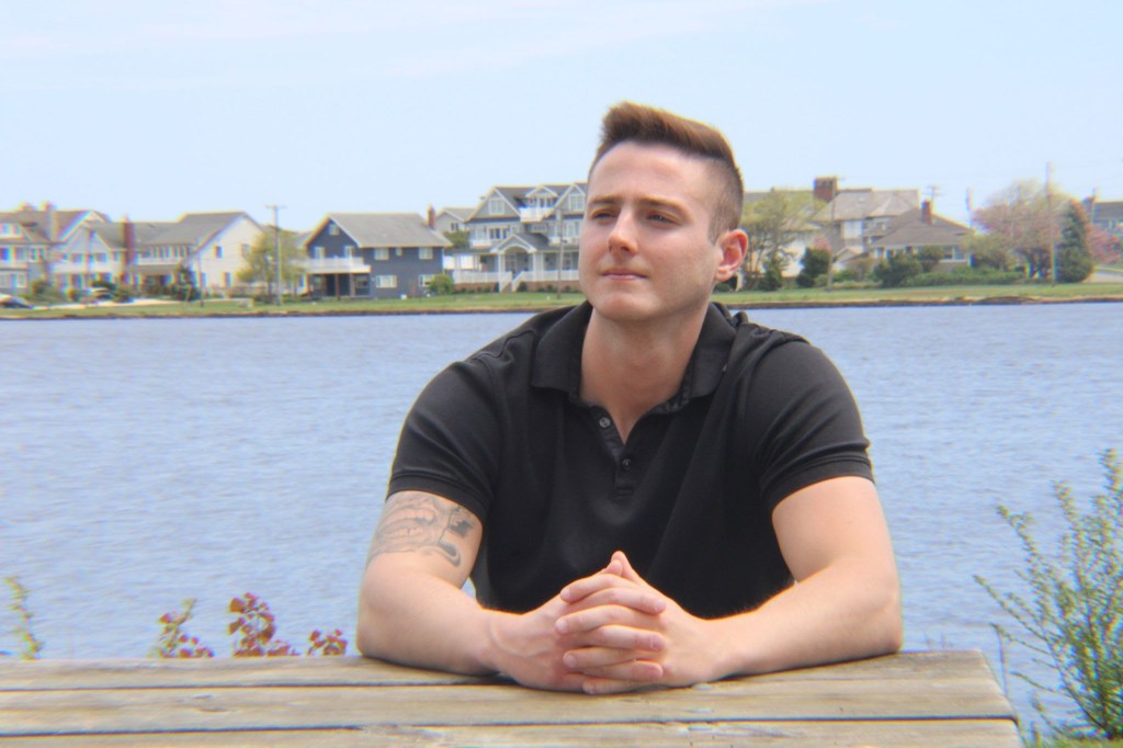 Dan Adams sitting by the water. Photo courtesy of Rob Stein. 